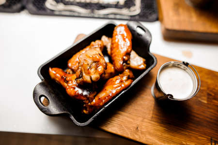 Chicken wings baked in a frying pan close upの写真素材