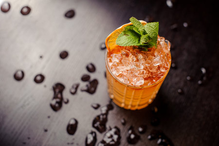 Bright cocktail with mint leaves and an orange slice close up