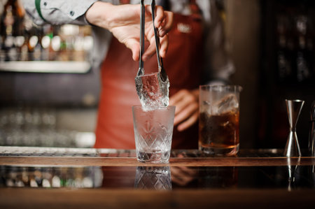 A professional bartender is holding an ice. close upの写真素材