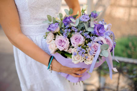 Stylish beautiful bride holds a wedding bouquet in hands. No faceの写真素材