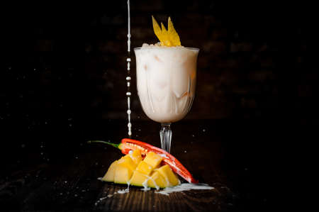 Spicy mango cocktail on wood table and black backgroundの写真素材