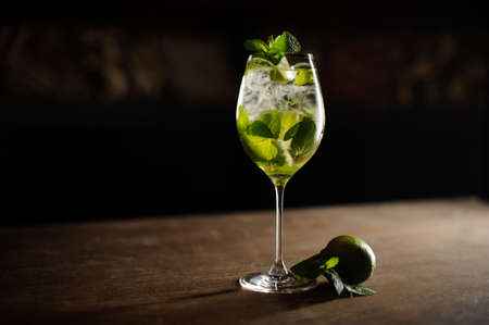 Mojito cocktail with lime and mint in highball glass on a dark stone background Copy spaceの写真素材