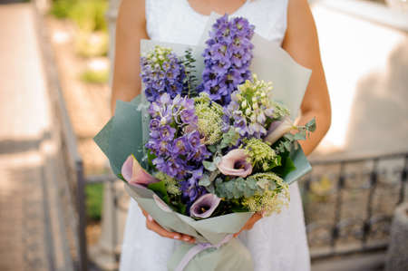 Lovely colorful wedding bouquet in woman hands on a bright background no face close upの写真素材