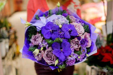 Bright and elegant winter bouquet of beautiful flowers in woman hands. No face, close upの写真素材