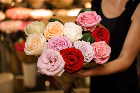 Elegant and beautiful bouquet of colorful big roses in woman hands. No face, close upの写真素材