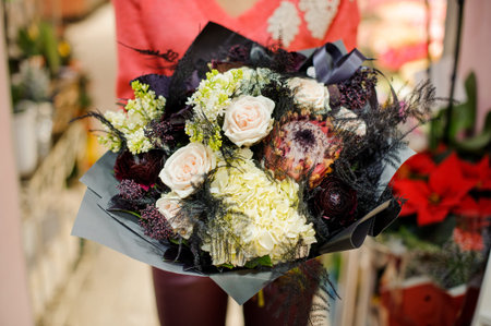 Stylish and elegant winter bouquet of flowers in woman hands. No face, close up photoの写真素材