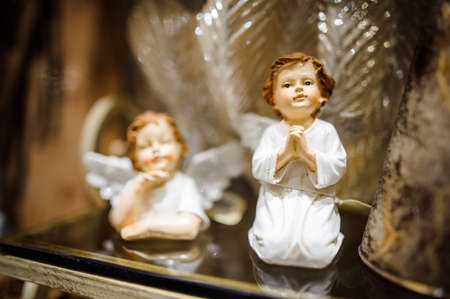Christmas toy in the form of two cute porcelain praying little angels in white clothingの写真素材
