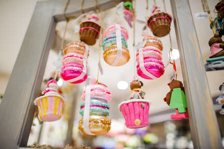 Cute colorful glass Christmas tree toys in the form of tasty cupcakes on the bright backgroundの写真素材