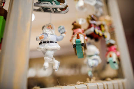 Christmas tree toy in the form of little and cute Santa Claus on skates dressed in grey clothingの写真素材
