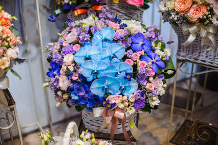 Cute and gorgeous festive wicker basket with a beautiful and colorful flower composition. Close up photoの写真素材