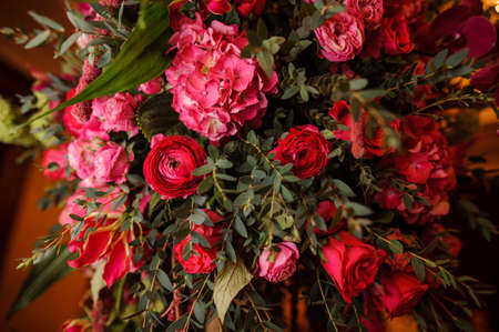 Gorgeous bouquet of bright and pink, red flowers with green leafs on the dark backgroundの写真素材