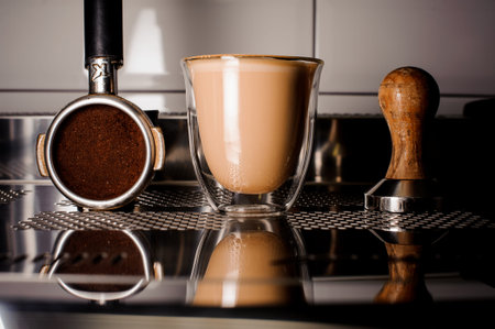 Barista equipment for making coffee and cup of coffee on the light background of coffee machine