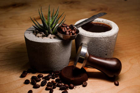 Fashionable and cute pots with coffee drink and plant, coffee beans on the wooden tableの写真素材