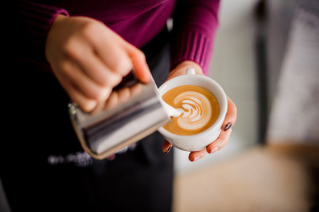 Barista making coffee latte art in a coffee shop on the white and blurred backgroundの写真素材