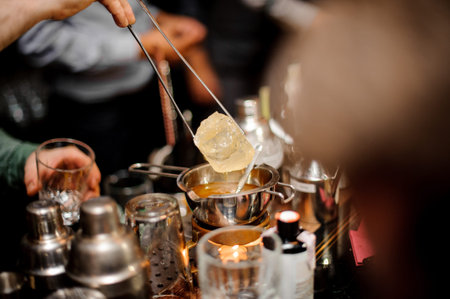 Process of making cocktail with help of accessories on the bar counter on the light and blurred...
