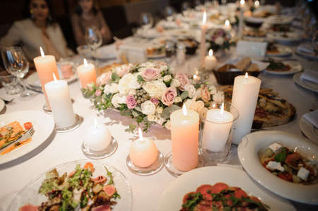 Table served with tasty dishes and decorated with candles for a celebration dinner in luxury restaurant. Celebration conceptの写真素材