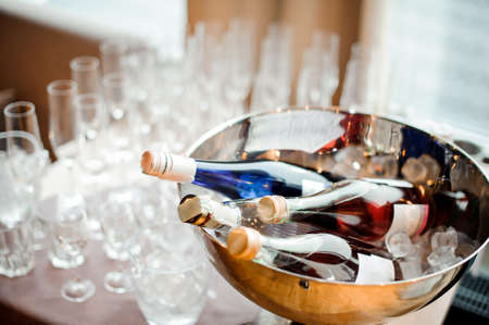 Bottles of alcoholic beverages and set of empty glasses on the table in front of the window. Alcohol conceptの写真素材