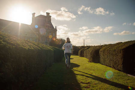 Young girl walking along the beautiful European gardenの写真素材