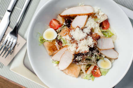 Delicious classic Caesar salad served in the white plate with cutlery near it. Food conceptの写真素材