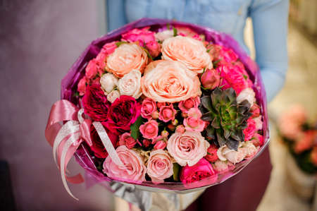 Large and gorgeous pink bouquet of flowers in womans hands on the blurred background. Bouquet conceptの写真素材