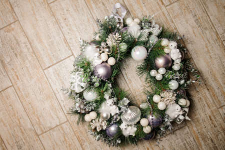 Beautiful Christmas decoration wreath made of fir tree and decorated with white toys and ballsの写真素材