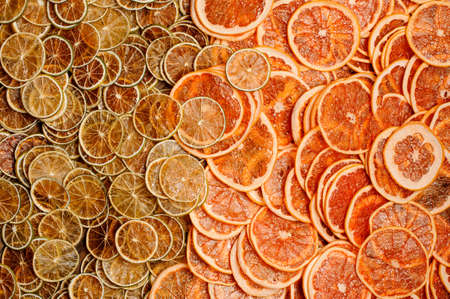 Top view of a large amount of neat, fresh and tasty slices of juicy orange and lemon fruits arranged chaoticallyの写真素材