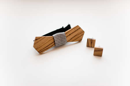 Men accessories. Elegant and stylish wooden bow tie and cufflinks arranged on the white backgroundの写真素材