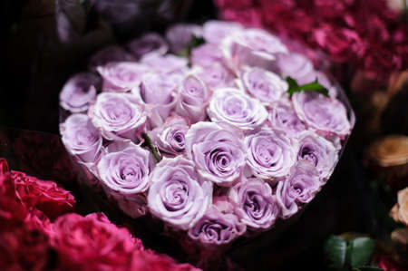 Bouquet of flowers consisting of tender lilac roses wrapped in a black paper in a flower shopの写真素材