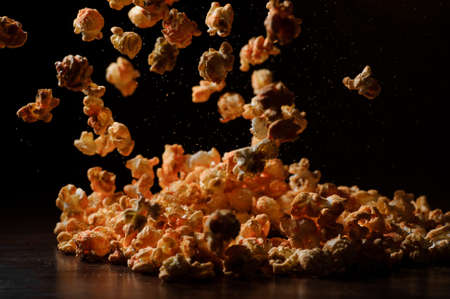 Set of fresh warm salty popcorn with cheese taste on the table against the black backgroundの写真素材