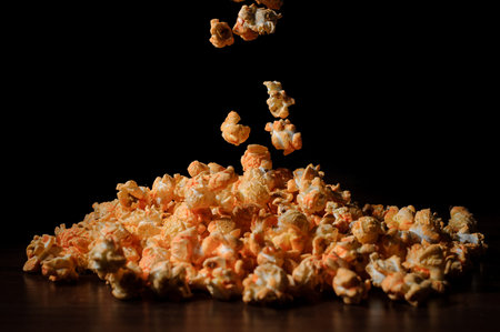 Fresh and warm salty popcorn with cheese taste on the table against the black background