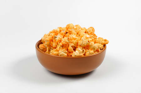 Brown deep plated filled with fresh salty popcorn with a cheese tase isolated on a white backgroundの写真素材