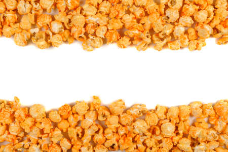 Delicious yellow popcorn lying on the white background and making a white field between themの写真素材