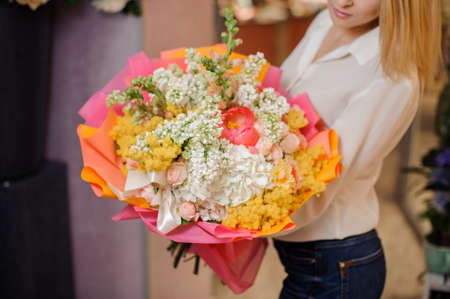 Girl holding a beautiful bright bouquet of white lilacs and rosesの写真素材