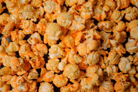 airy grains of yellow delicious roasted popcorn a thick layer was poured onto the surfaceの写真素材