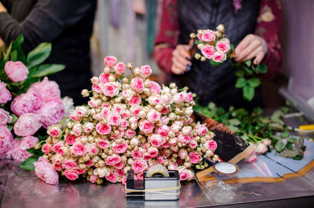 Floral artist preparing an amazingly beautiful pink and champagne colour little roses to putting into a bouquetの写真素材