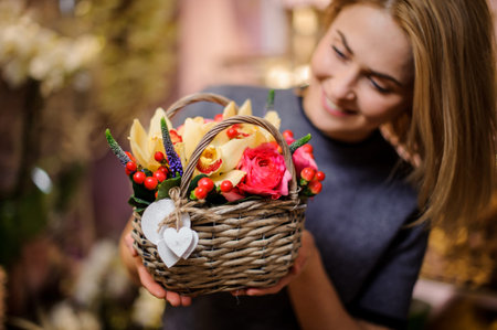 Girl holding in her hands a beautiful spring basket of yellow orchids, violet hyacinth and pink ranunculusの写真素材