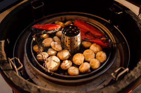 Top view of tasty fresh red peppers and champignons mushrooms being cooked on the grillの写真素材