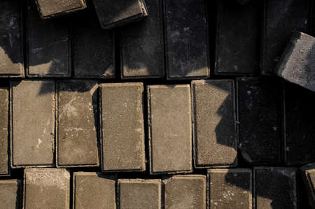 Close up and top view texture background of a set of grey building bricks under the sunの写真素材