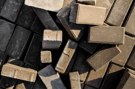 Close up and top view texture background of randomly scattered grey building bricks under the sun lightの写真素材