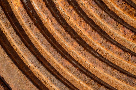 Close up macrophotography texture of the round rusty metal lines on the brown concrete groundの写真素材