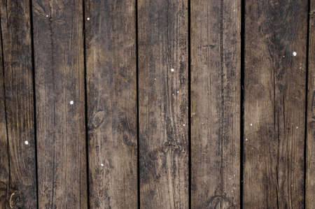 Close up texture background of old dark wooden boards vertically arranged in a wall with slotsの写真素材