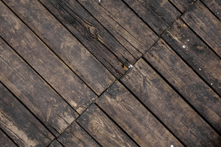 Close up texture background of old dark wooden boards asymmetrically arranged in a floor with slotsの写真素材