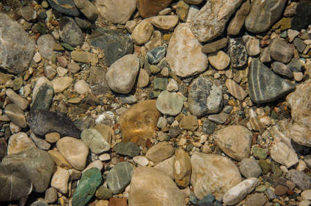 Background image of the different shape and size brown and grey sea rocks. Rocks ground textureの写真素材