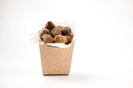 Delicious isolated chestnuts with sweet chilli and teriyaki sauce in paper bag on white backgroundの写真素材