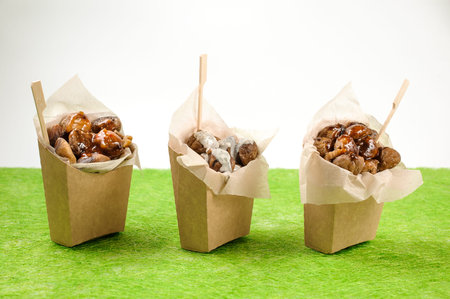 Set of three isolated paper packs filled with tasty chestnuts with sweet chilli, teriyaki and blue...