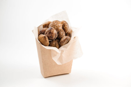 Spicy and fresh chestnuts filled in paper pack with tasty teriyaki sauce on bright white background...