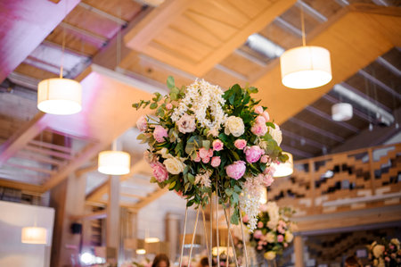 Wedding decor bouquet of tender pink peonies and roses with green leaves on the blurred background...