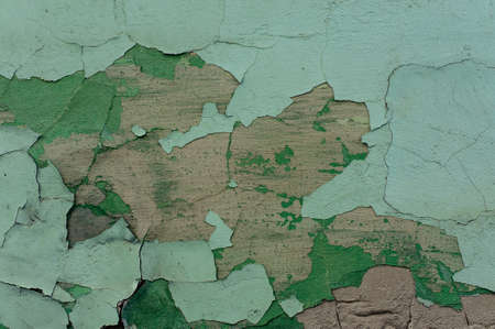 Macro photo of old concrete exterior wall painted in light green peeled off paint colorの写真素材