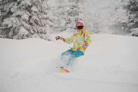 Girl riding down on the snowboard on the powdered snow in the mountain popular tourist resort in Goderzi, Georgiaの写真素材