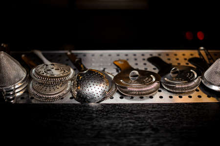 Different shape sieves on the steel bar counter ready for bartender praparing a delicious cocktailsの写真素材